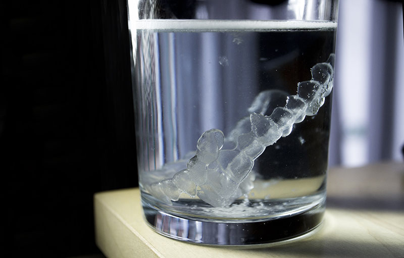 Invisalign soaking in a glass